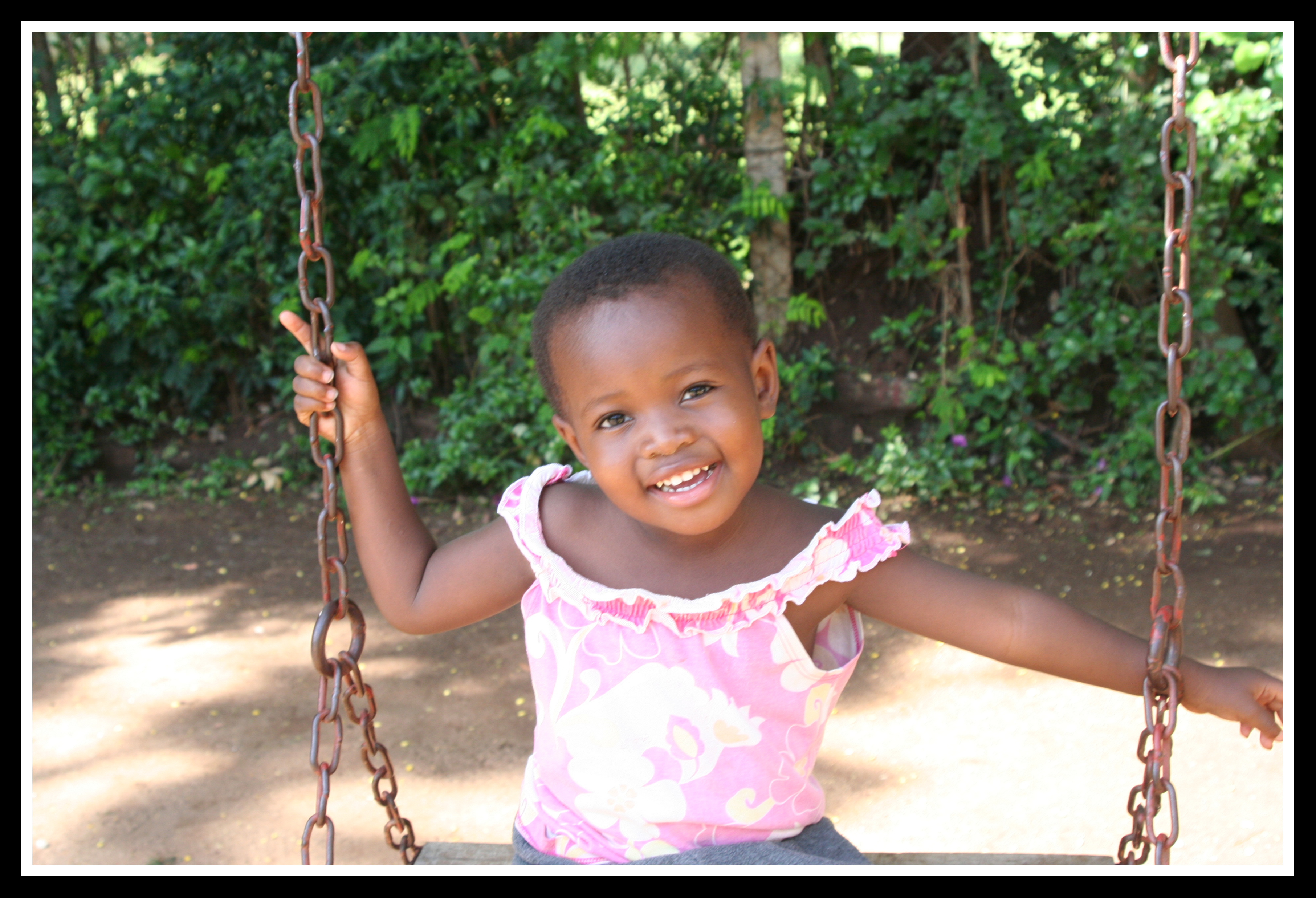 Justina on a swing at Treasures of Africa Children's Home - April 2009 - a few months before her third birthday